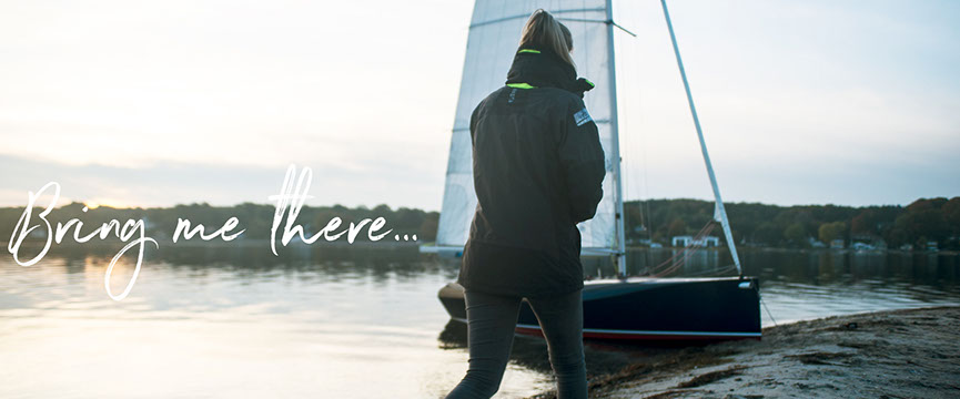 Wandersegeln mit der KARU-Jolle. Jollensegeln mit Zeltplane. Eine KARU-Jolle liegt am Strand.